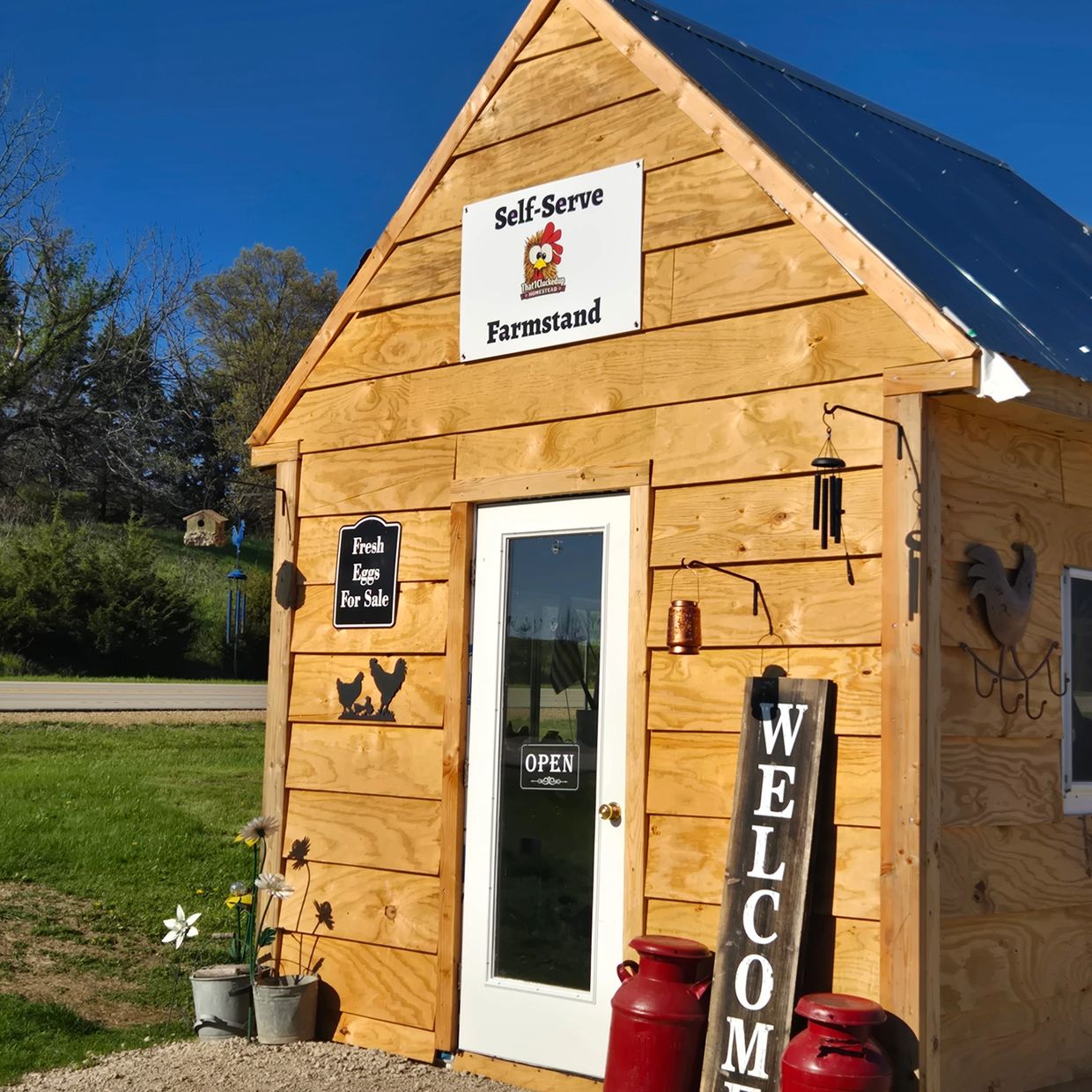 Wooden self-serve farmstand selling fresh eggs with welcoming decor.