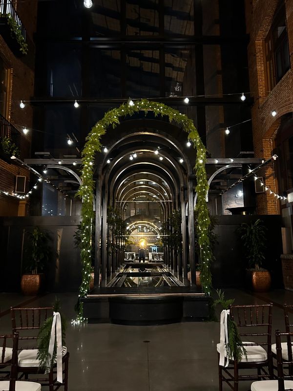 Cedar bows and fairy lights wedding arch at the court in the square belltown Seattle 