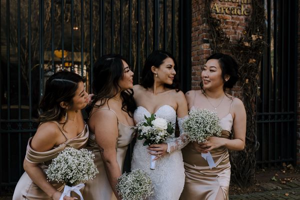 white babys breath bridesmaid bouquets, wearing gold dresses, small with rose bridal bouquet with ba