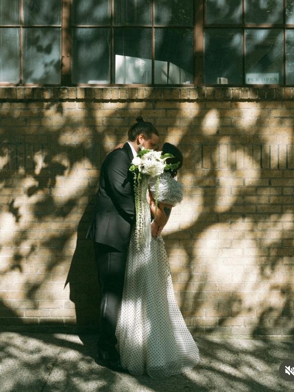 kissing wedding portrait with modern cascading bridal bouquet bride in vintage polka dot dress