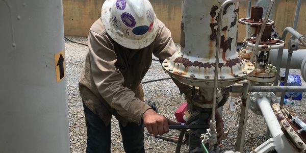 man working on repairing an old field machine