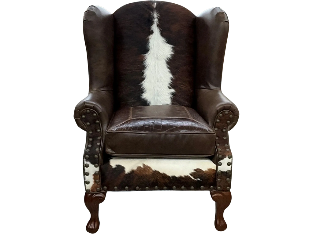 Elegant wingback chair with brown leather and cowhide upholstery.