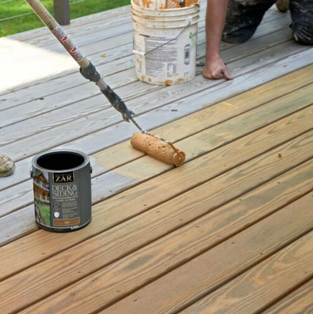 Pools & More technician applying sealant to wood deck for added protection in Port Orange.