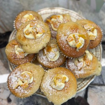 Plate of decorated cupcakes with nuts and powdered sugar.