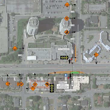 Aerial view of a road construction site with traffic signs and pedestrian management on North Rd.
