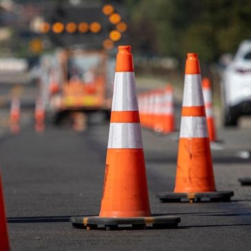 Row of orange traffic cones on a street directing traffic.