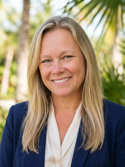 Smiling woman with long blonde hair in a navy blazer.