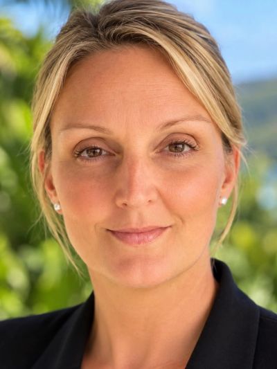 Close-up portrait of a smiling woman outdoors.