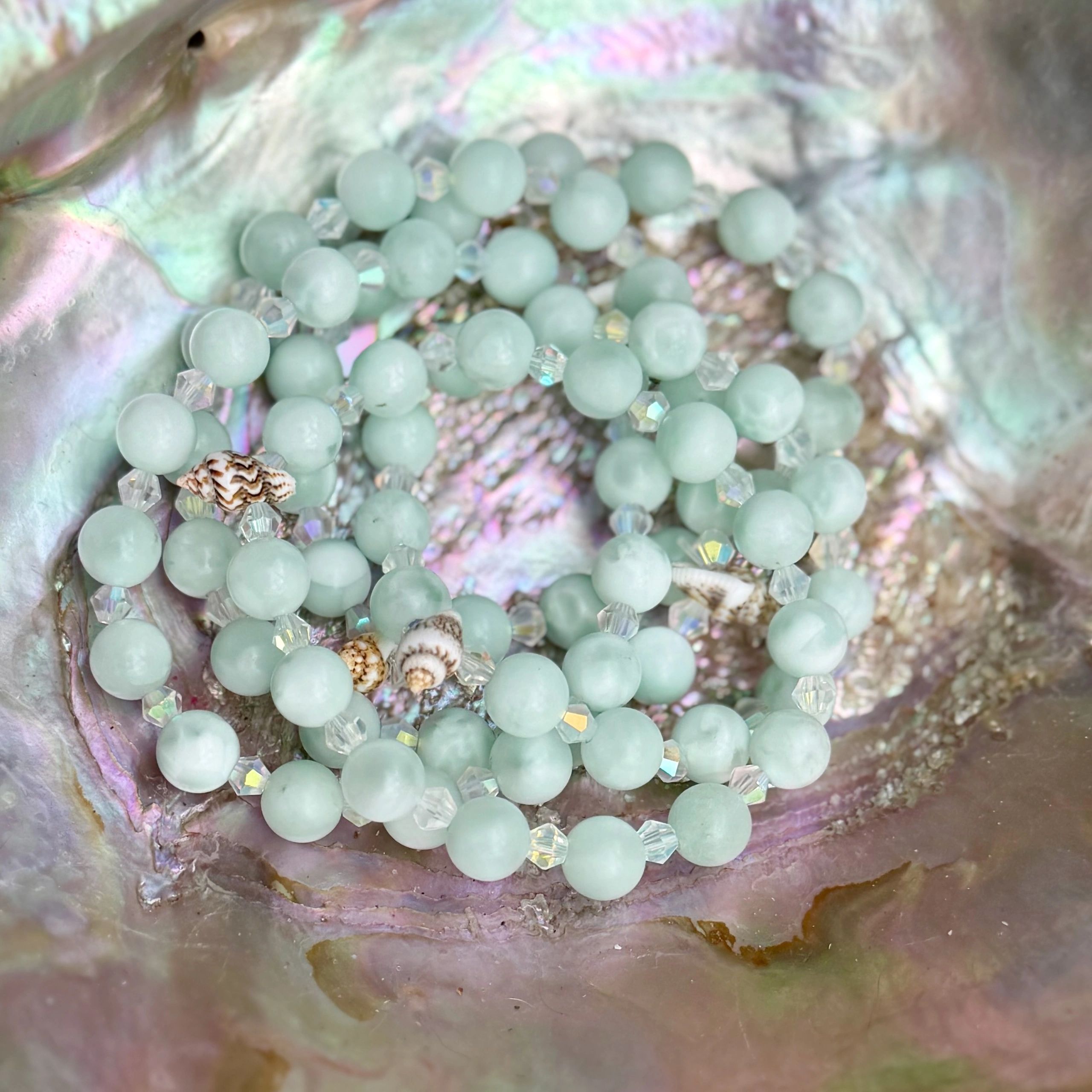 Light green beads on an iridescent shell.