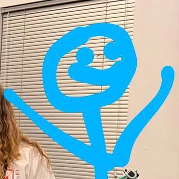 Blue stick figure drawing with raised arms near window blinds.