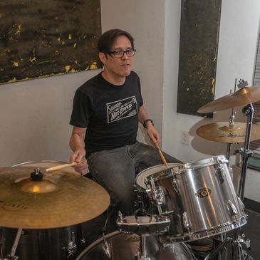 Person playing drums in a room.