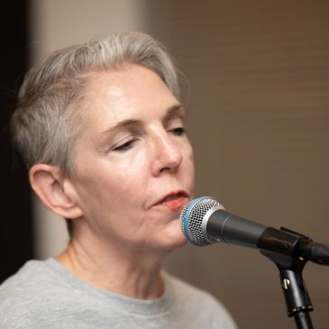 Person singing into a microphone.