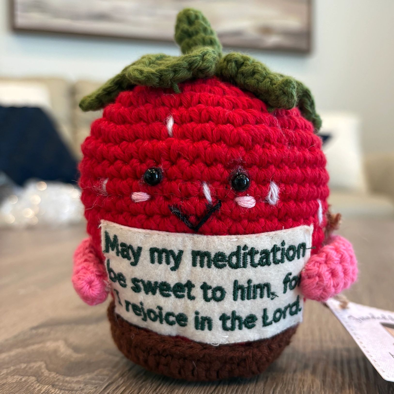 Crocheted strawberry with a positive meditation message.