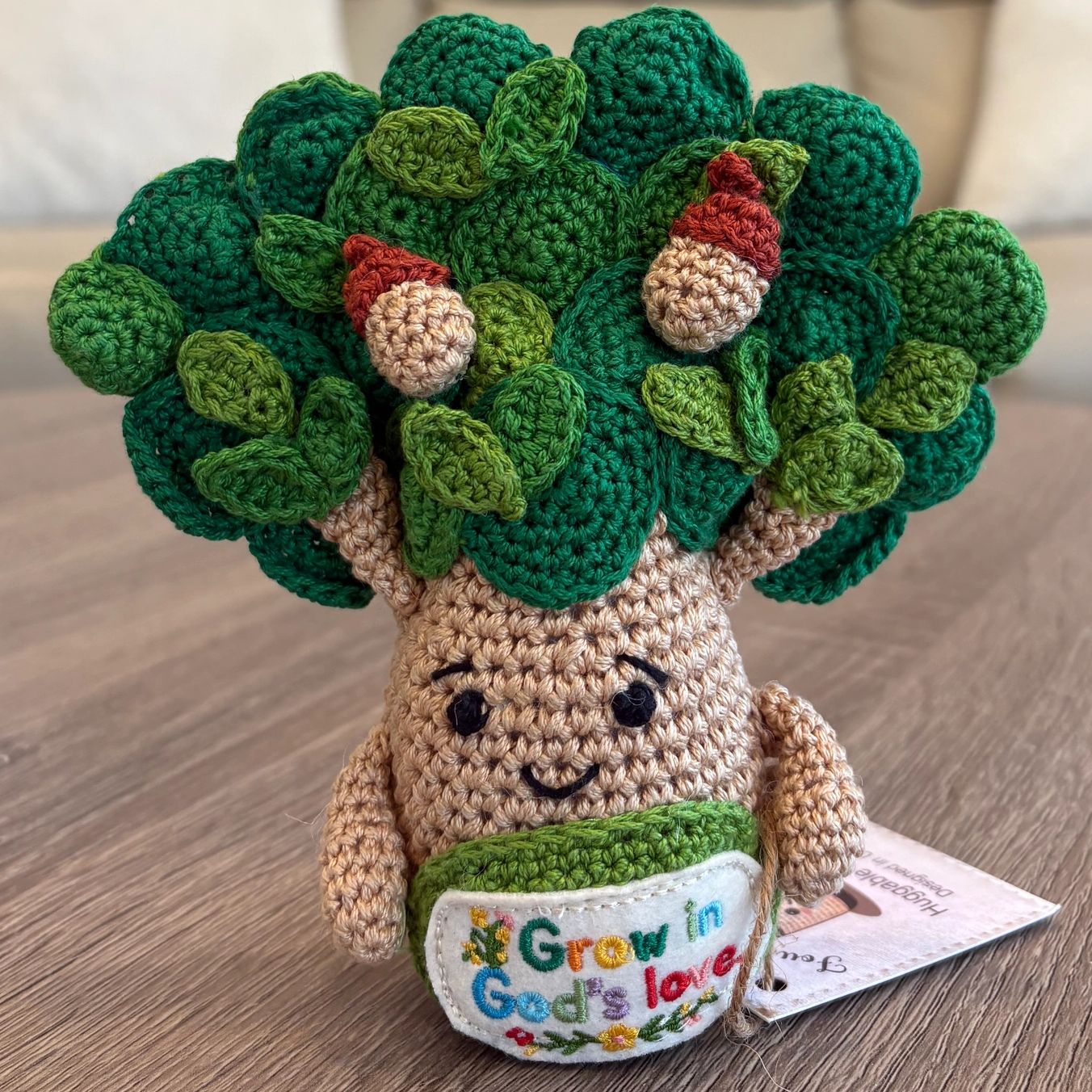Crocheted broccoli with a smiling face and acorns.