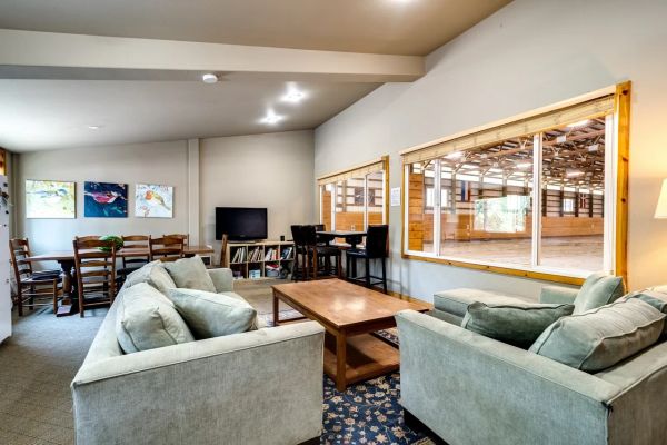 Cozy living room with sofas facing a window overlooking an indoor arena.