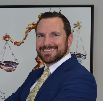 Smiling man in a blue suit with a Constitution-themed tie.
