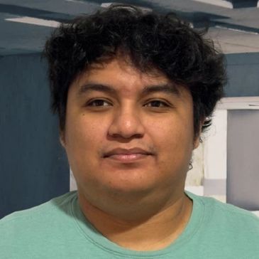 Portrait of a young man with curly dark hair.