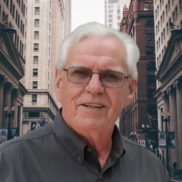 Elderly man with glasses smiling in an urban street setting.