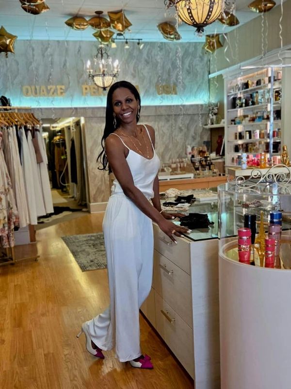 Woman in white outfit smiling inside a boutique.
