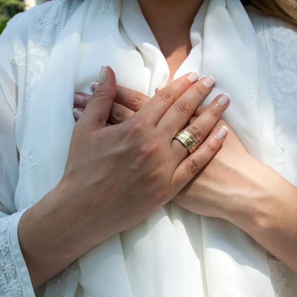 Lady in white holding both hands to her heart