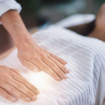 A woman receiving reiki on her abdomen