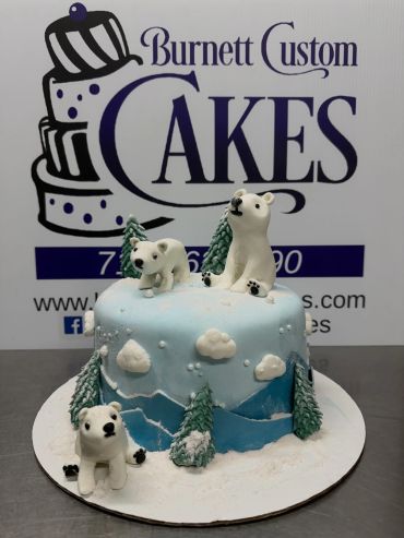 Winter-themed cake with polar bears and snowy trees by Burnett Custom Cakes.