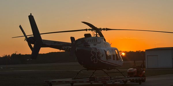Medical helicopter parked at sunset on a trailer.