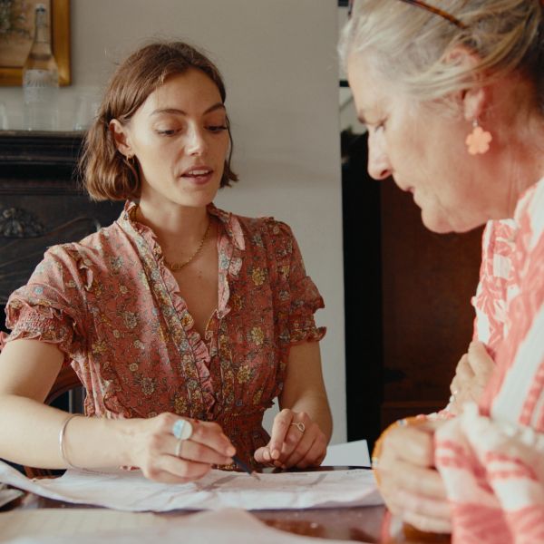 Two women discussing documents at a table.