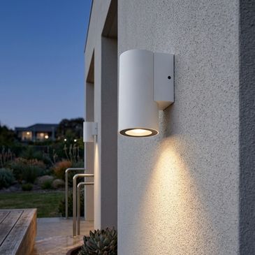 Modern white outdoor wall light on a textured wall.