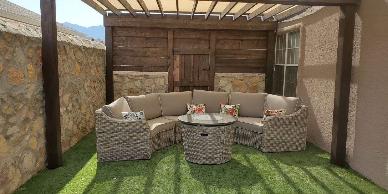 Cozy outdoor seating area with wicker furniture under a pergola.