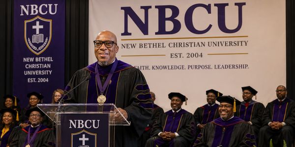 Man speaking at New Bethel Christian University graduation event.
