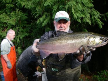 Man proudly holding a large fish caught during fishing.
