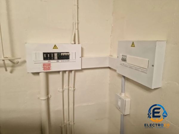Electrical panels mounted on a beige wall corner.