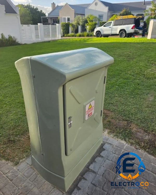 Electrical utility box outdoors with a white truck in the background.