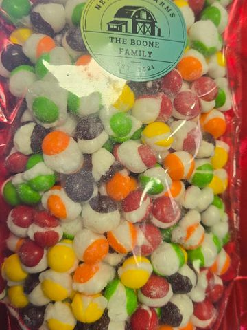 Colorful candy-coated nuts in a clear bag with a family farm label.