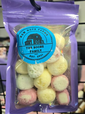 Colorful round candies in a purple resealable bag with a blue label.