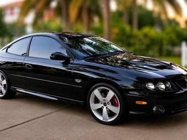 Sleek black sports car parked outdoors.