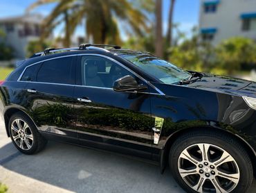 Shiny black SUV parked outdoors with reflections.