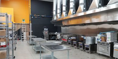 Image of an industrial kitchen with stainless steel surfaces and appliances