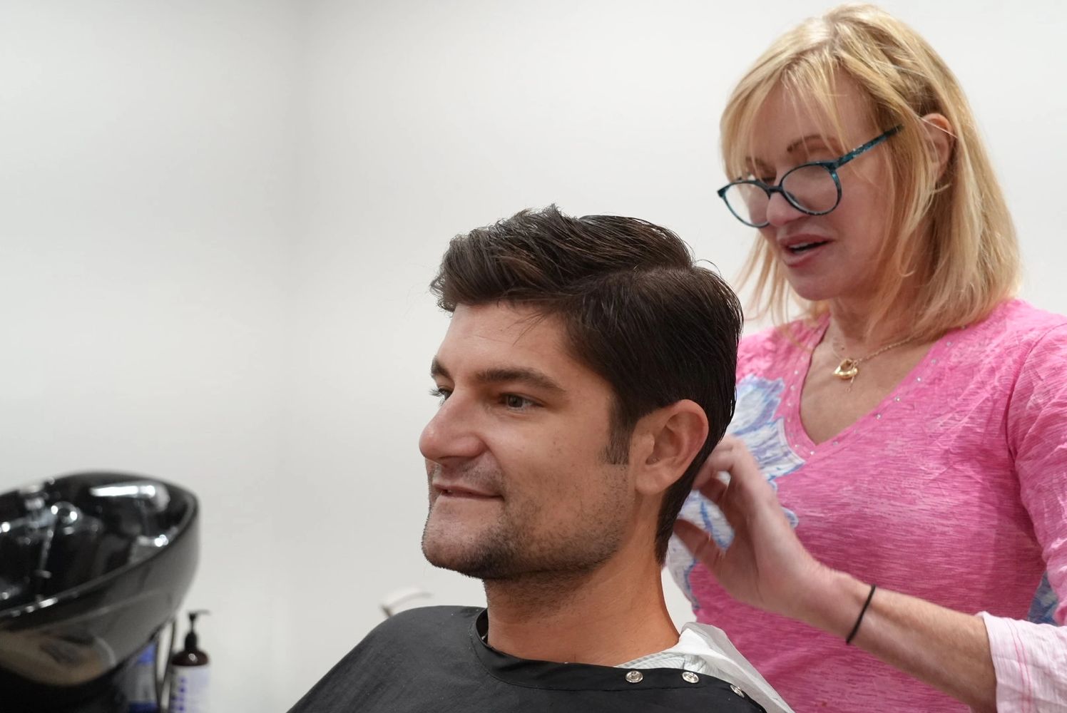 Man getting a haircut from a stylist in a salon.