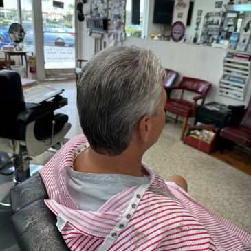 Man with freshly cut gray hair sitting in a barber chair.