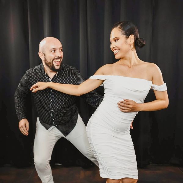 A dancing couple is having a great time sharing a Salsa song with great smiles on their face.