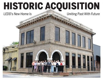 Group in front of historic brick building acquired by LEDD.