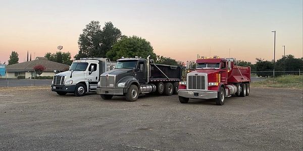 three dump trucks in a parking lot