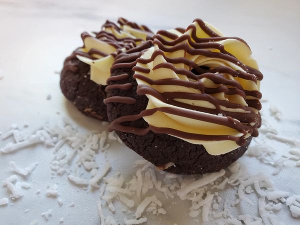Our soft chocolate sugar cookie with coconut. Traditional Nanaimo bar buttercream and a light drizzl