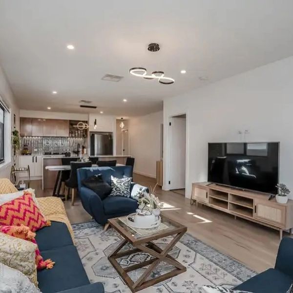 Modern open-concept living room and kitchen with stylish furniture and decor.