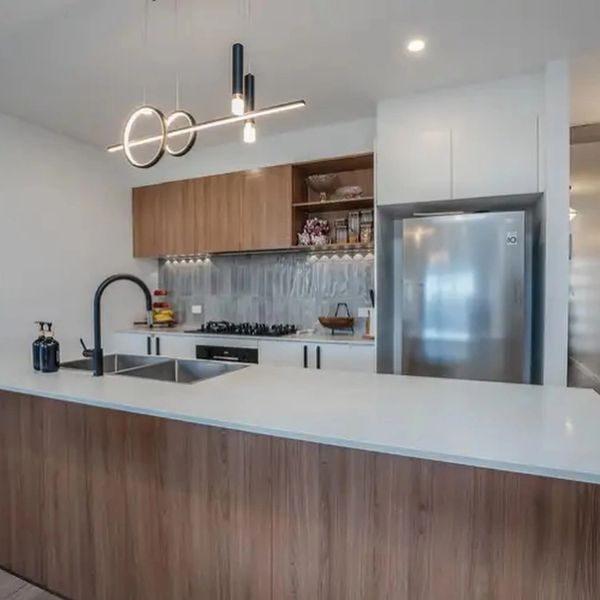Modern kitchen with wood and white finishes and unique lighting.