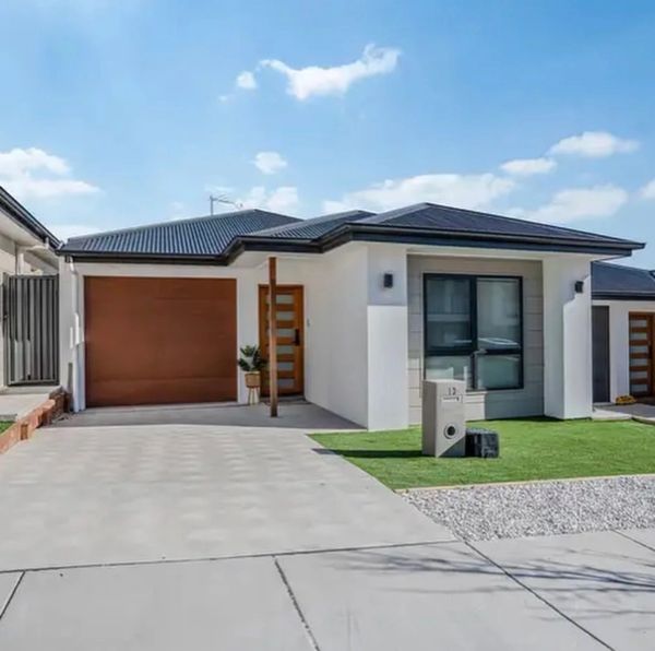 Modern single-story house with a brown garage door and neat driveway.