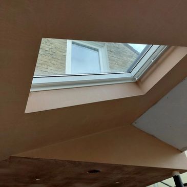 Image of a sky light and ceiling that has been plastered.