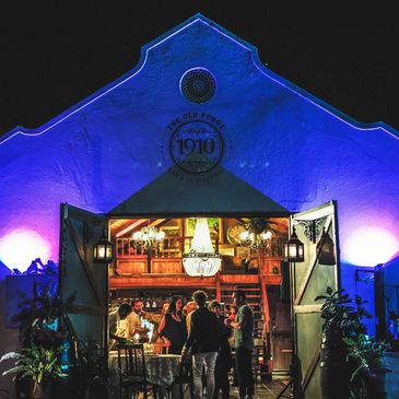 People socializing inside a warmly lit restaurant with blue exterior lighting at night.